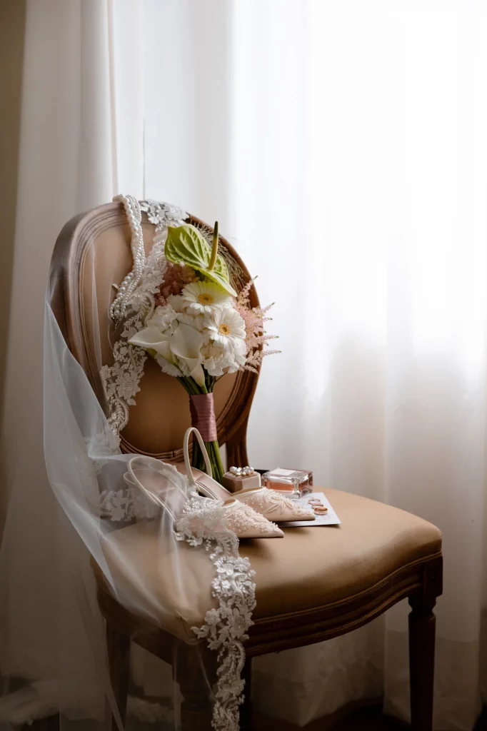 Brautschmuck mit Schleier, Blumen und Schuhen auf Stuhl