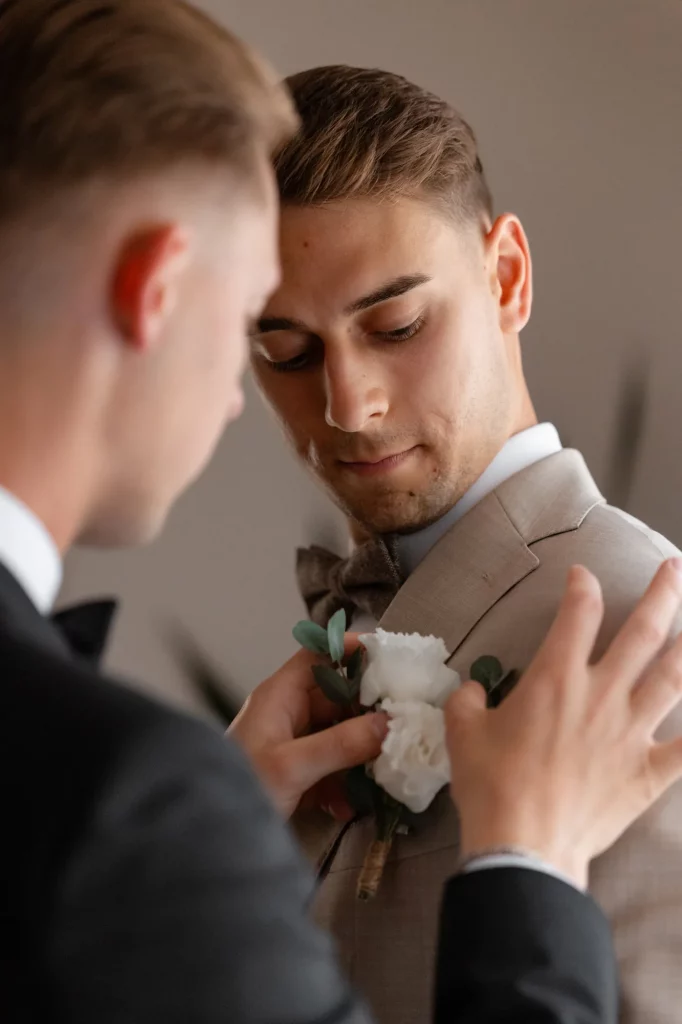Mann erhält weißen Blumenanstecker