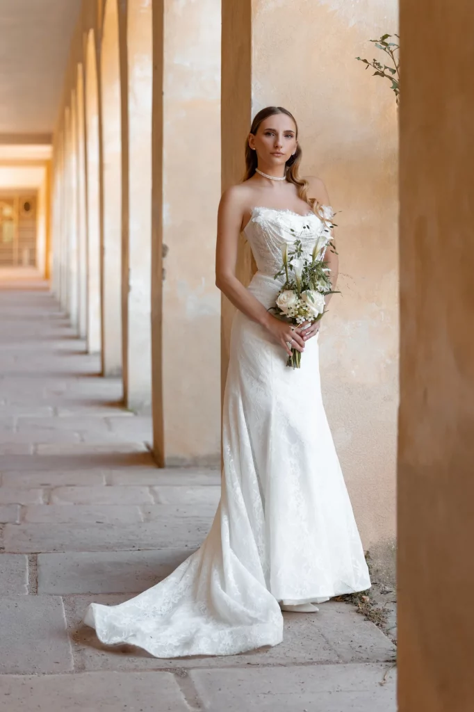 Braut in weißem Kleid mit Blumenstrauß