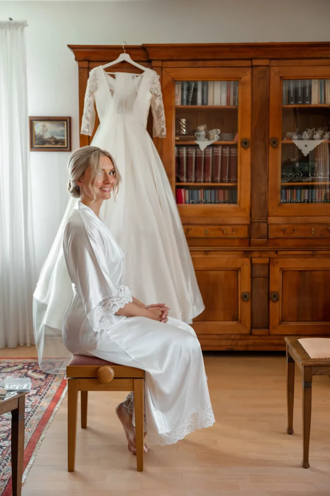 morning of the bride, the bride sits next to the dress