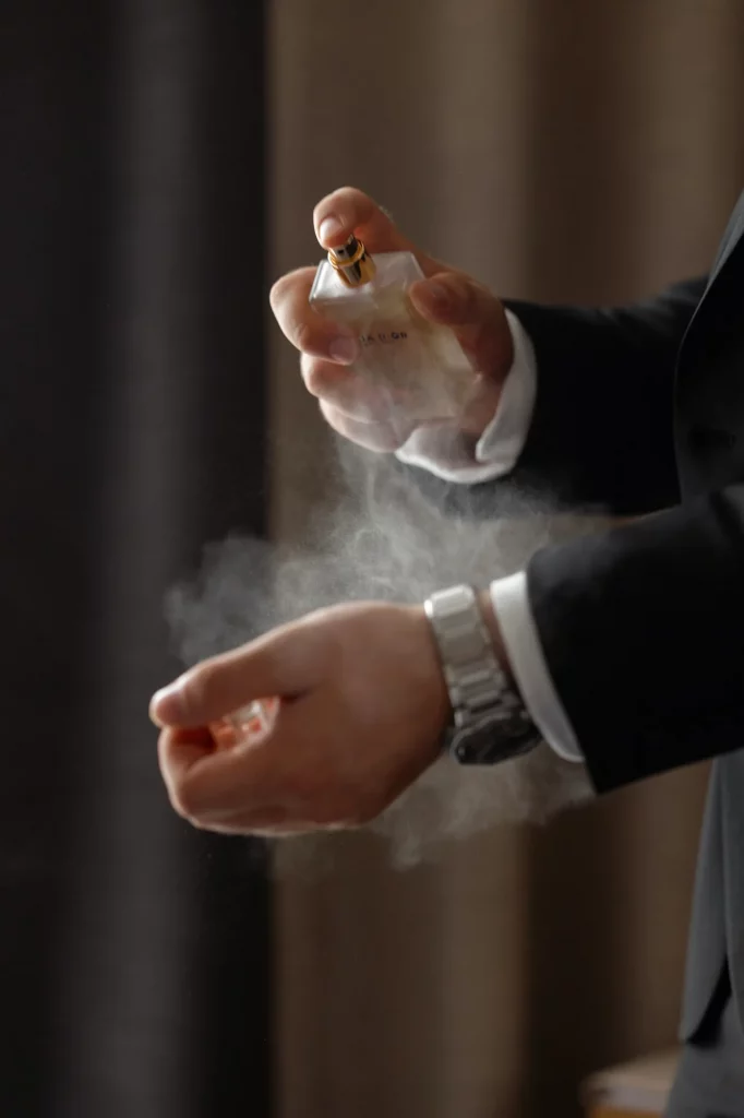 Mann sprüht Parfum auf Handgelenk