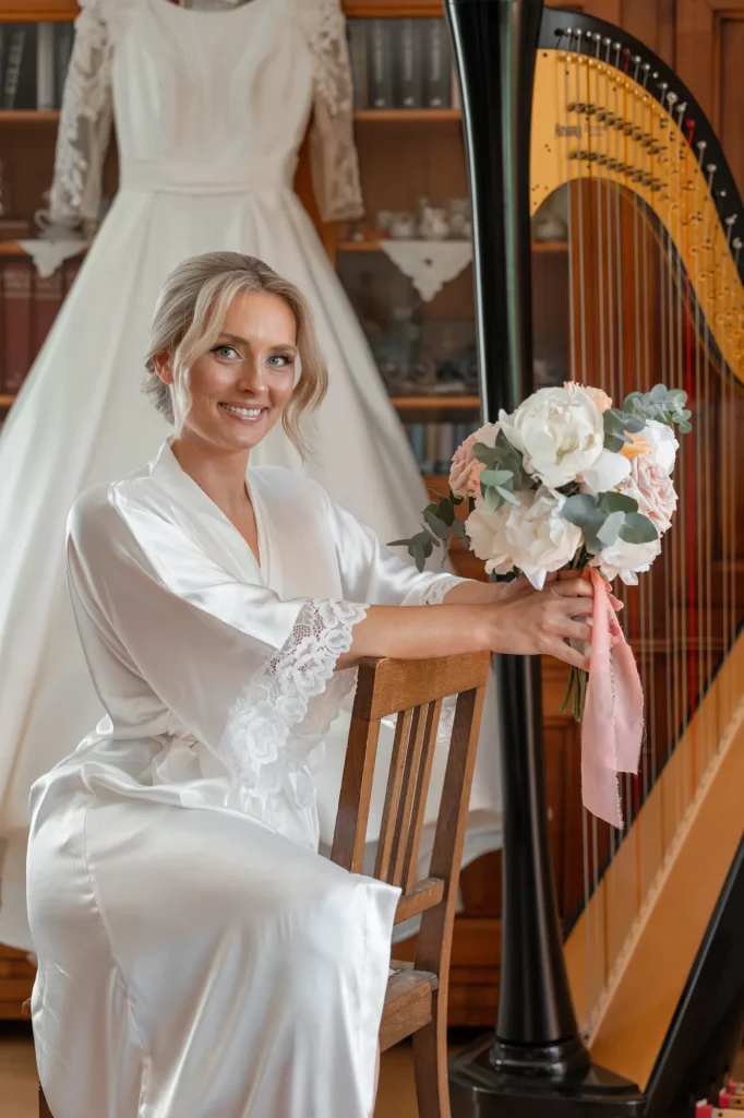 morning of the bride, a makeup artist does makeup for the bride, the bride sits with a bouquet against the background of the dress