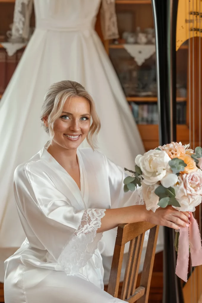 the bride sits with a bouquet against the background of the dress