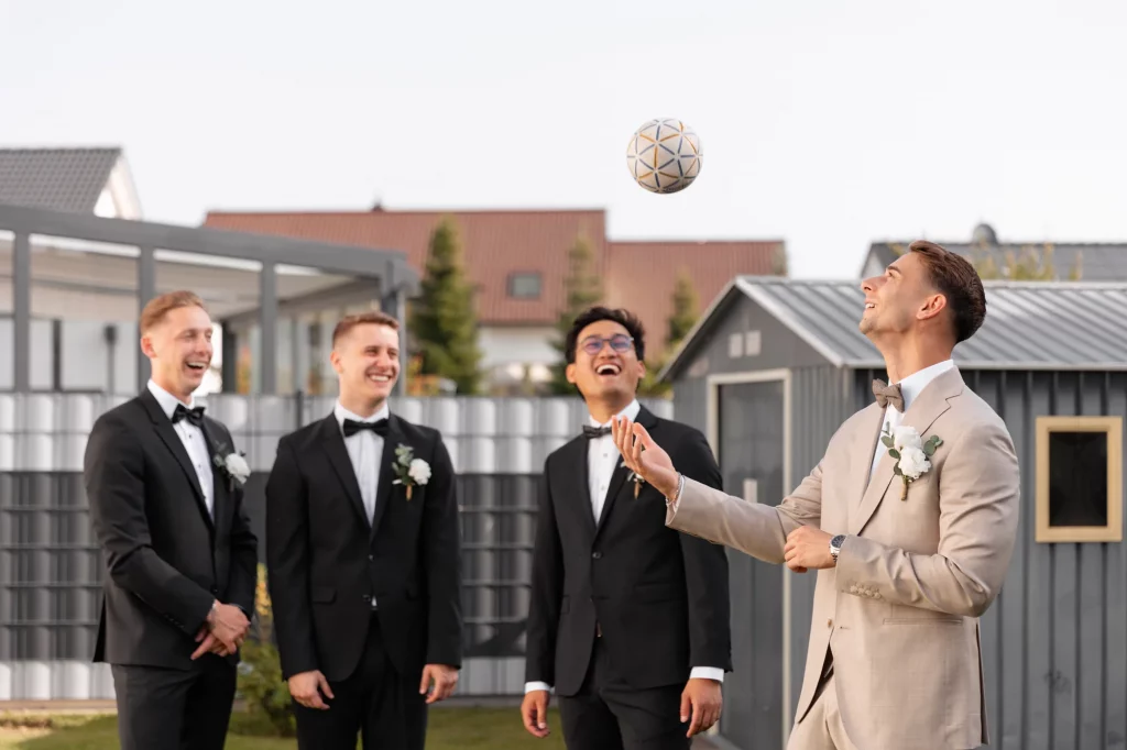 Braeutigam spielt mit Ball vor Gaesten