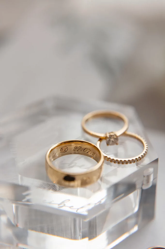 Goldene Ringe mit Gravur auf Glasunterlage