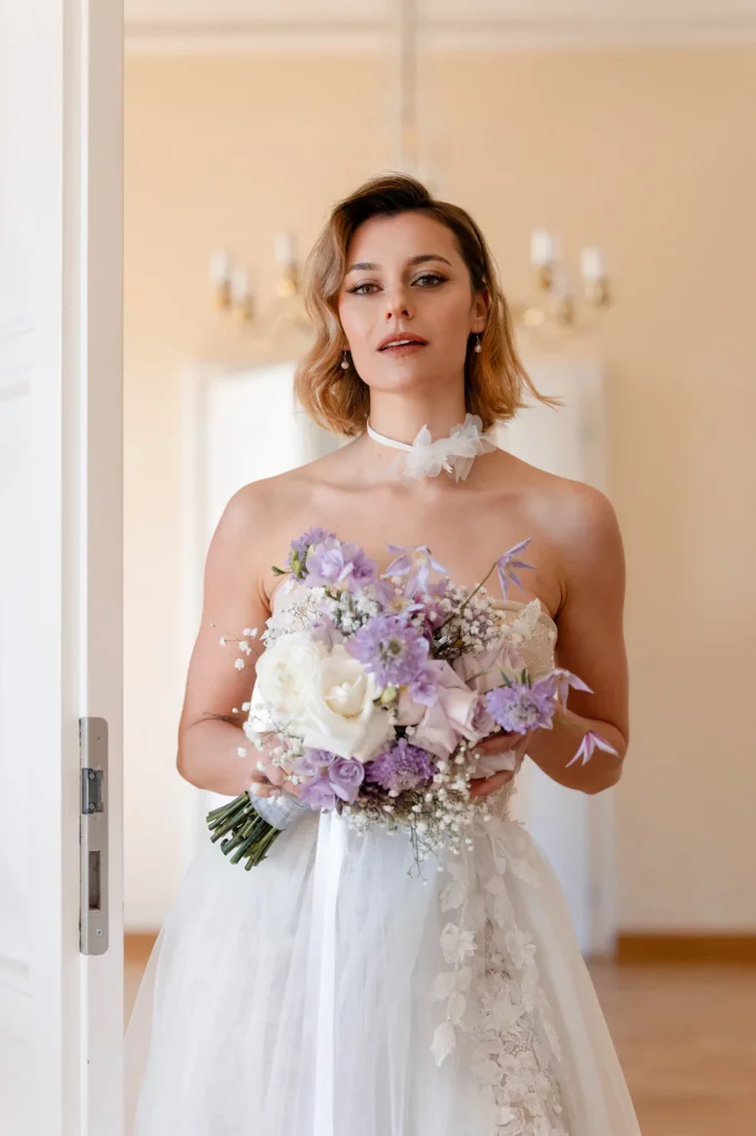 Braut mit lila und weißen Blumen