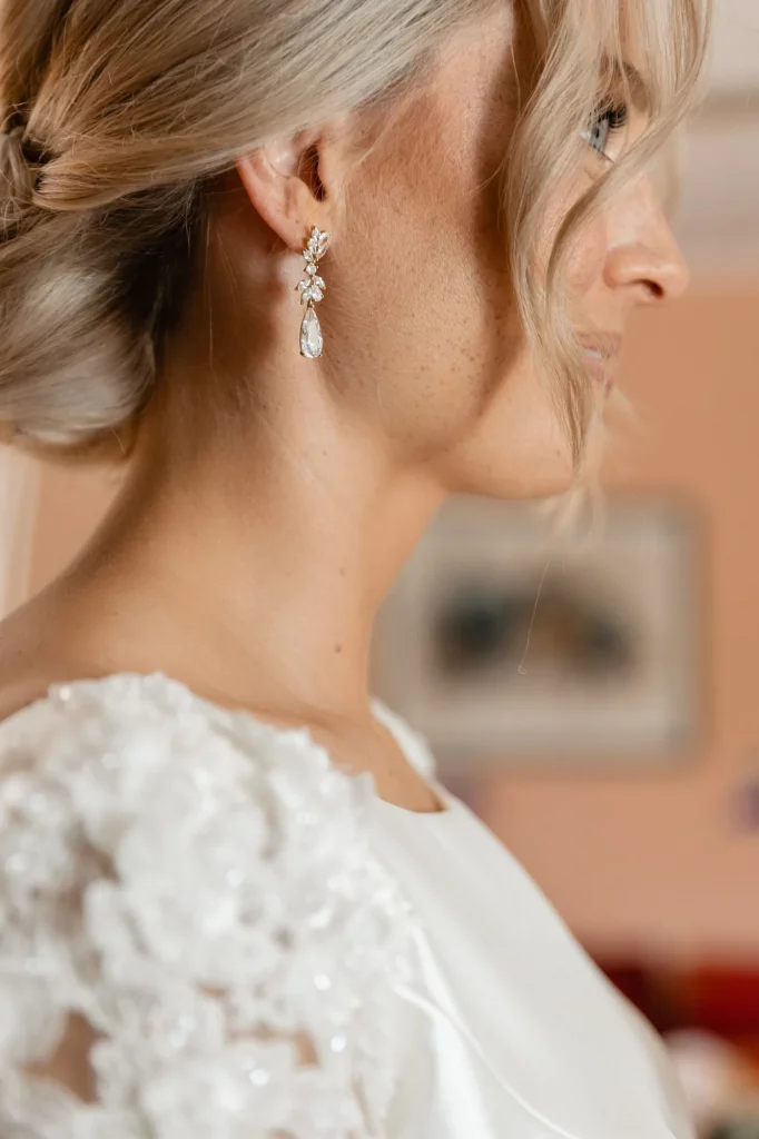 a clouse-up portrait of the bride from the side with a beautiful erarring hanging on her ear