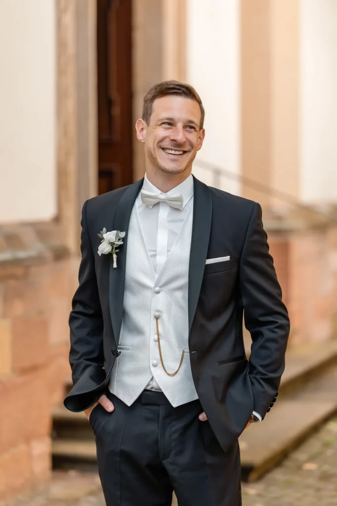 a portrait of the groom in a black suit waiting for his bride