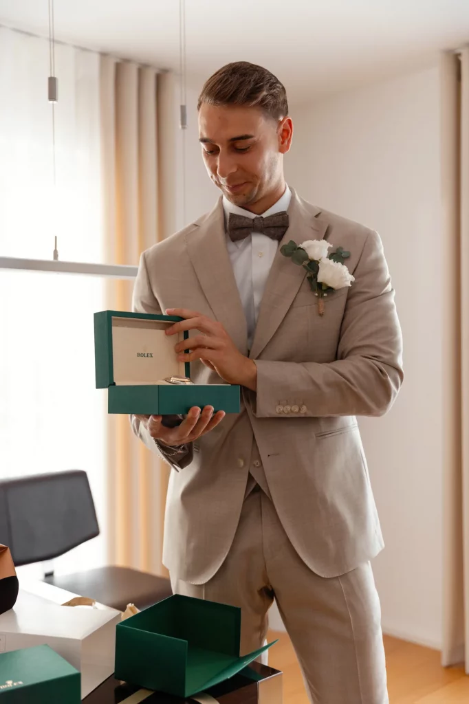 Bräutigam öffnet Geschenkbox mit Uhr