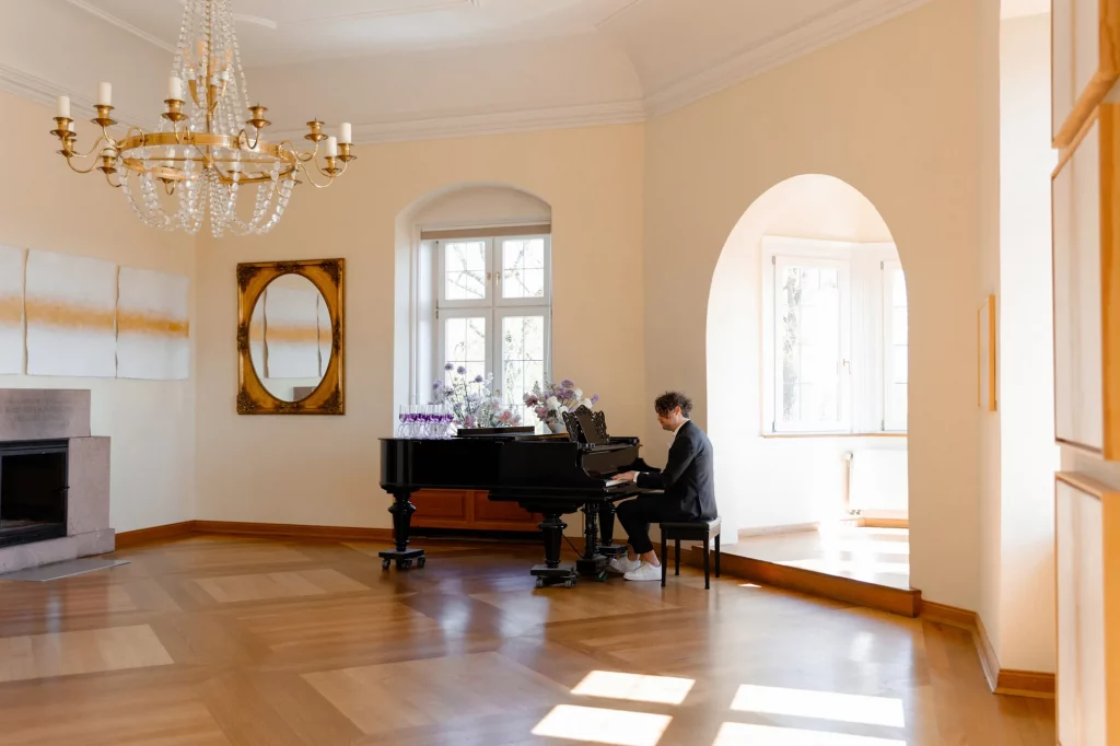 Mann spielt Klavier in hellem Raum