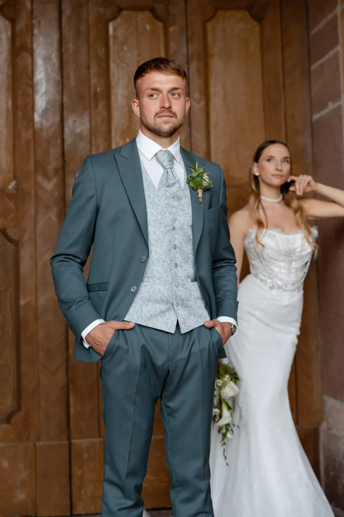 Bräutigam im Anzug vor Braut in Kleid