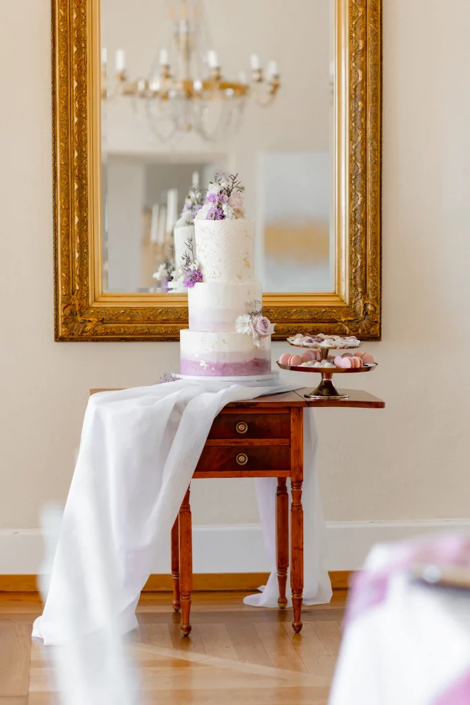 Dreistöckige Hochzeitstorte mit Blumen vor Spiegel