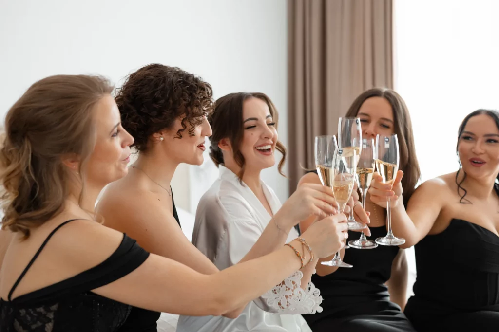 Frauen stoßen mit Sektgläsern an und lachen