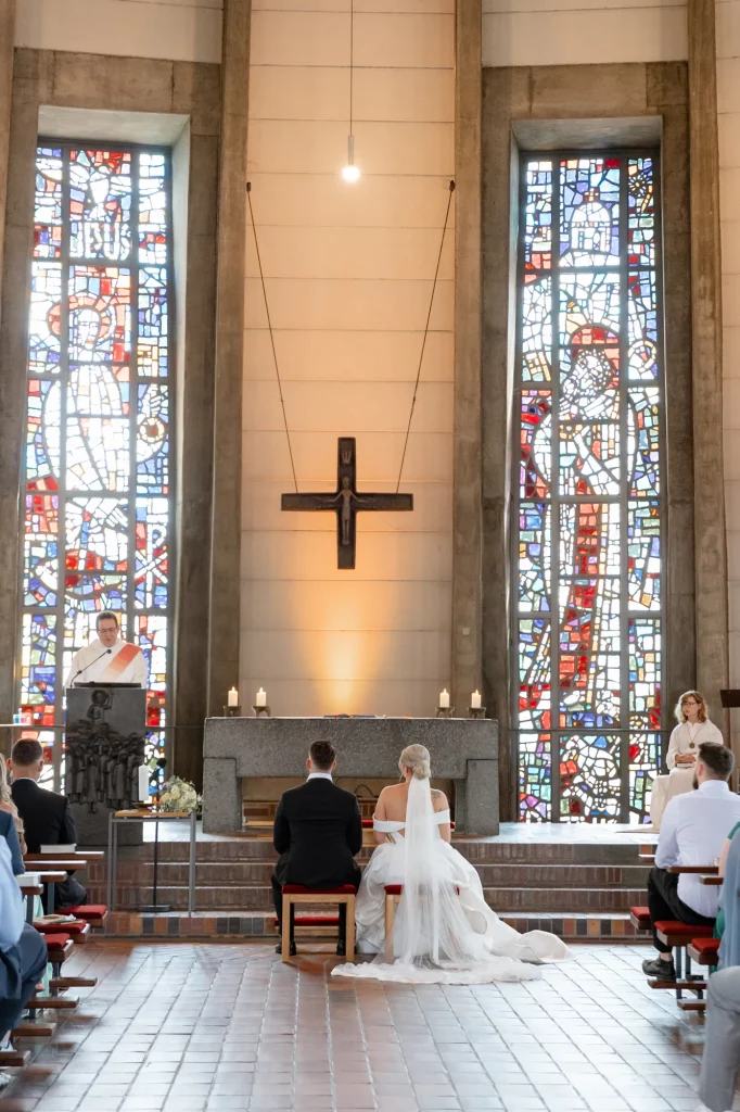 Brautpaar sitzt vor Altar in Kirche