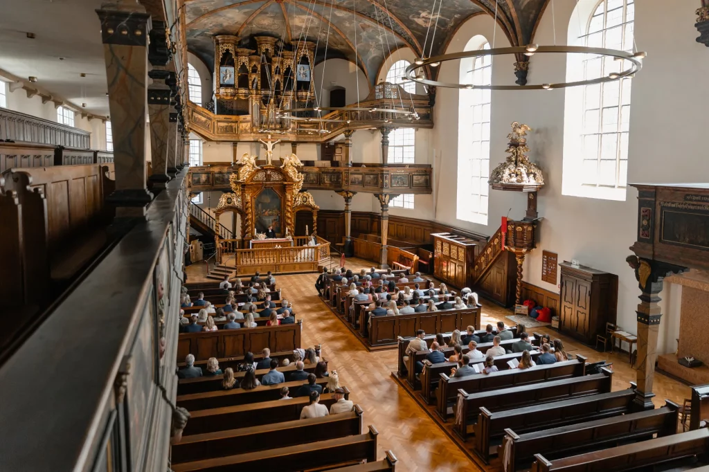 a wide shot inside the church during a wedding ceremony, wedding photographer