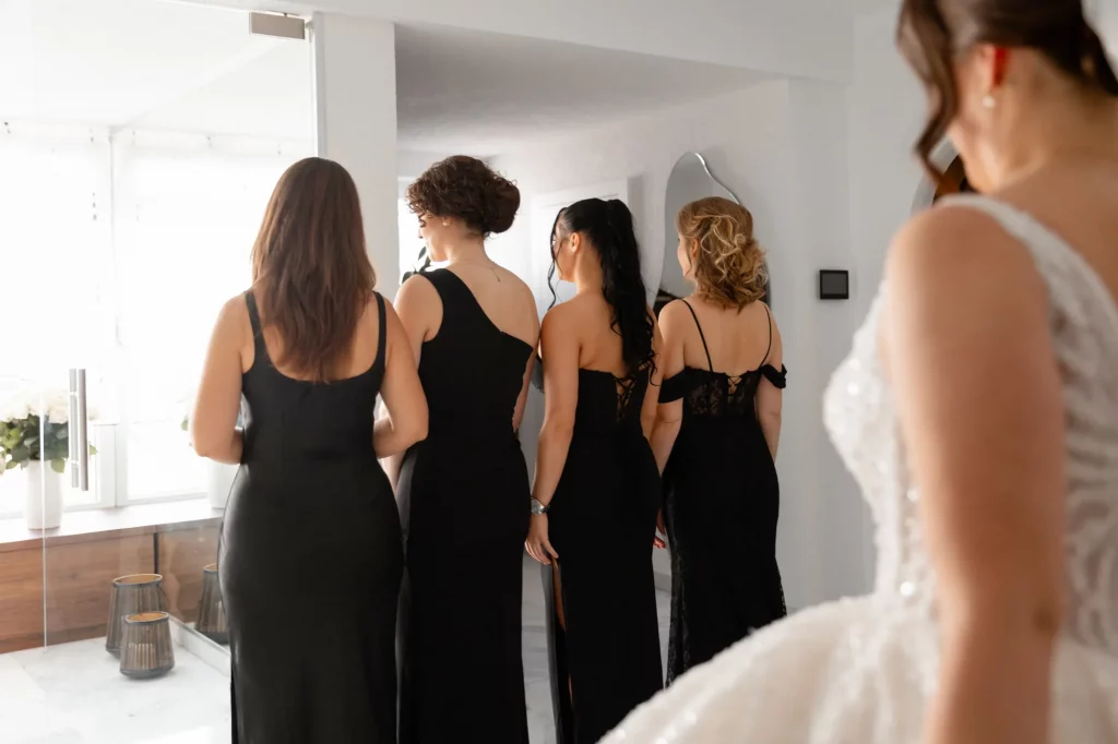 Vier Frauen in schwarzen Kleidern von hinten