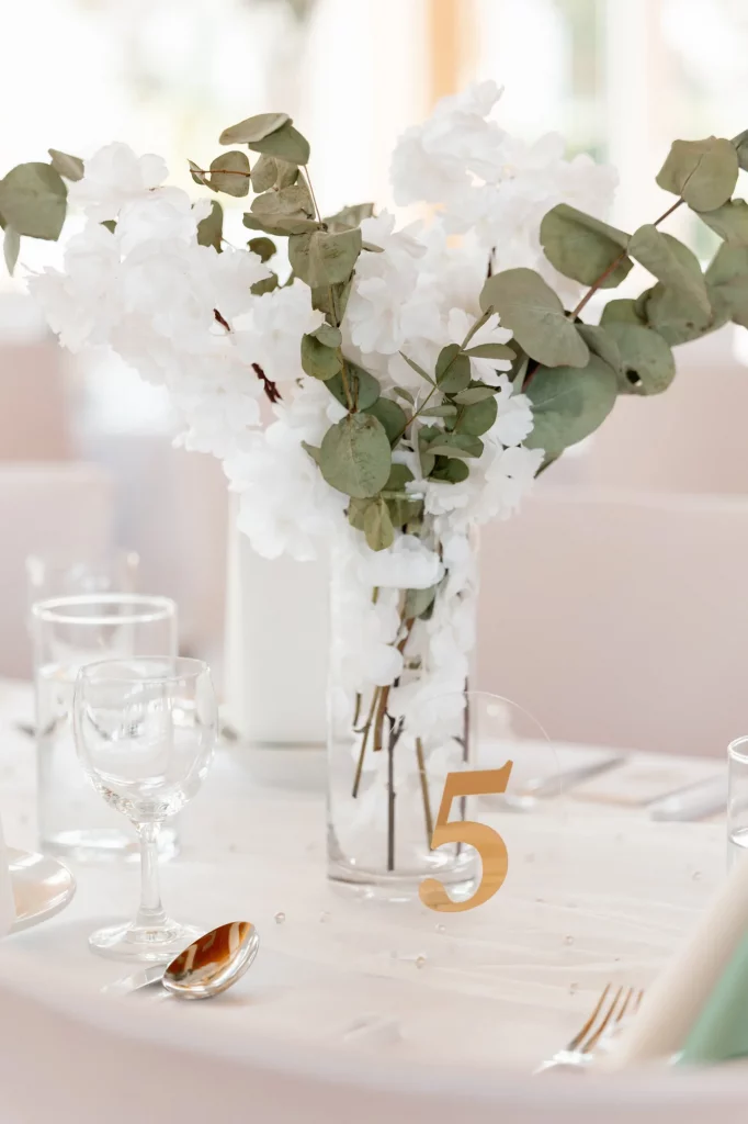 Weißer Blumenstrauß und Gläser auf gedecktem Tisch