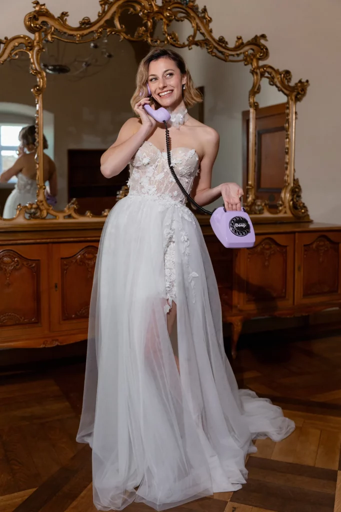 Braut im weißen Kleid telefoniert lachend