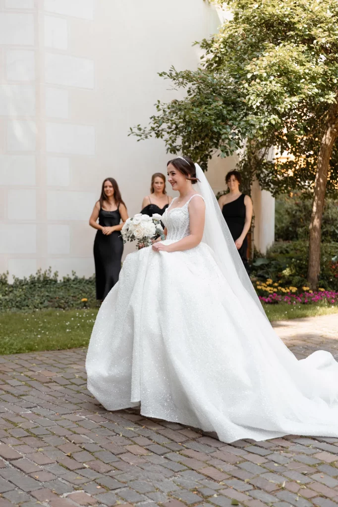 Braut mit weißem Kleid und Brautjungfern im Garten