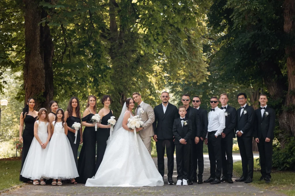 Brautpaar mit Hochzeitsgesellschaft im Park
