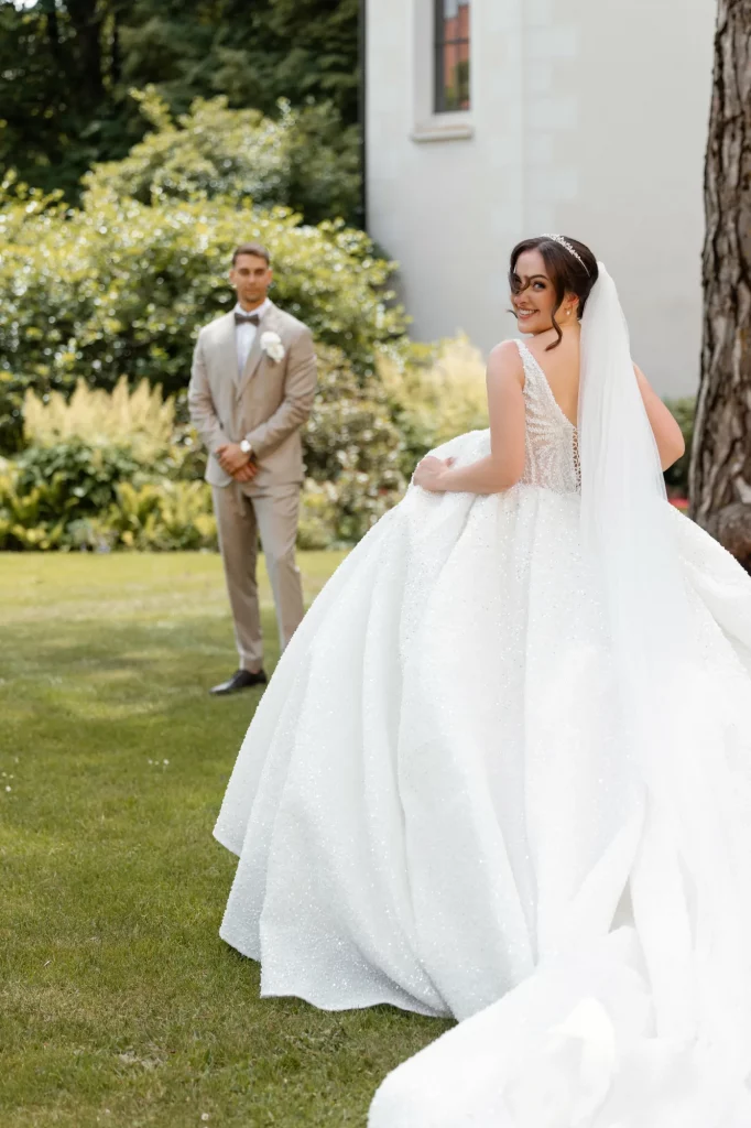 Braut im weißen Kleid mit Schleier im Garten