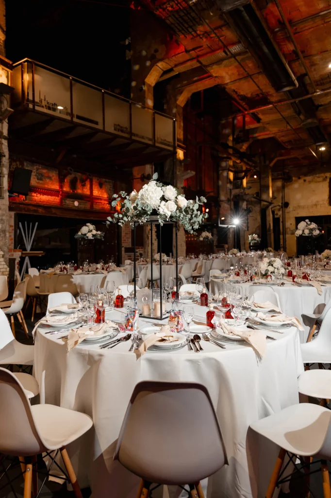 Festlich gedeckte Tische mit Blumen in Industriehalle