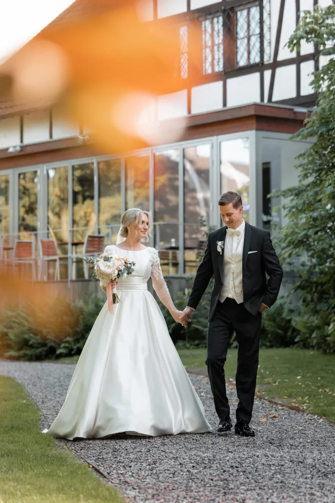 the wedding couple walks hand in hand