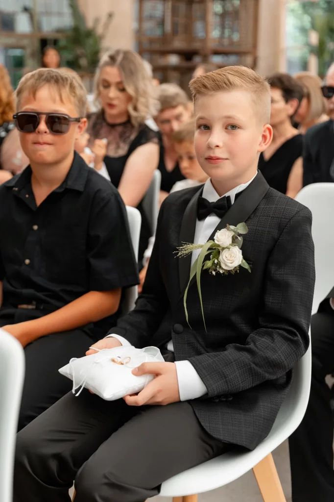 Junge mit Anstecker und Ringkissen bei Hochzeit