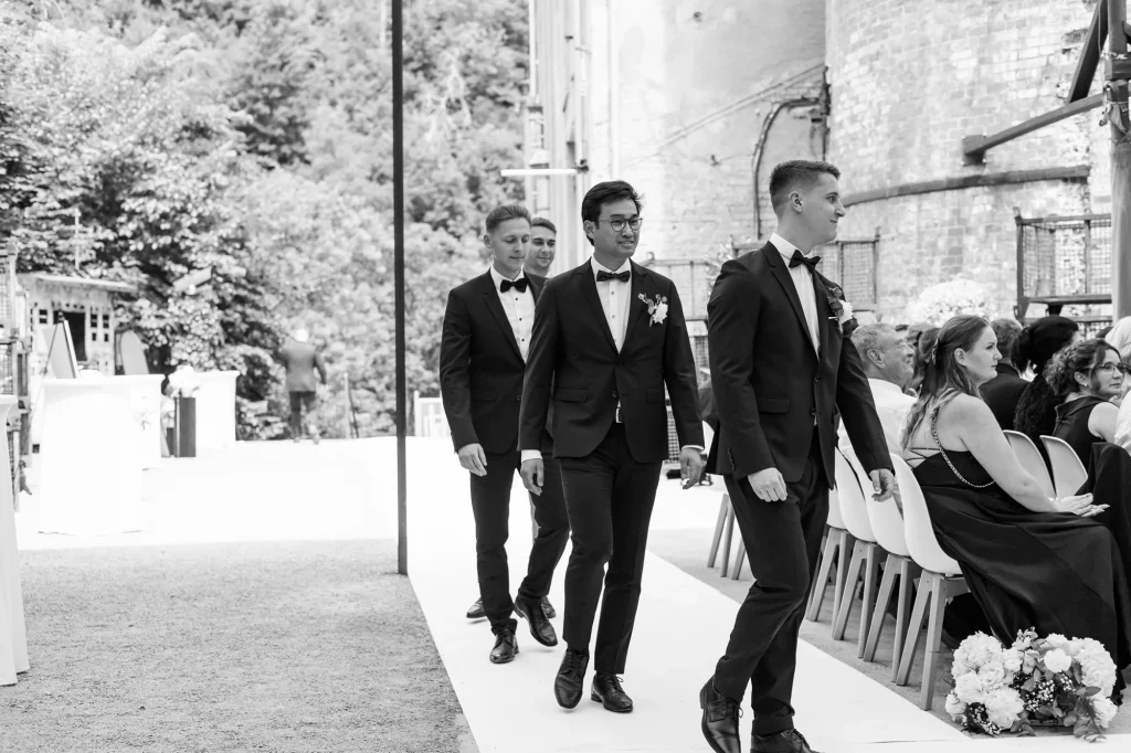 Vier Männer im Anzug gehen bei Hochzeit