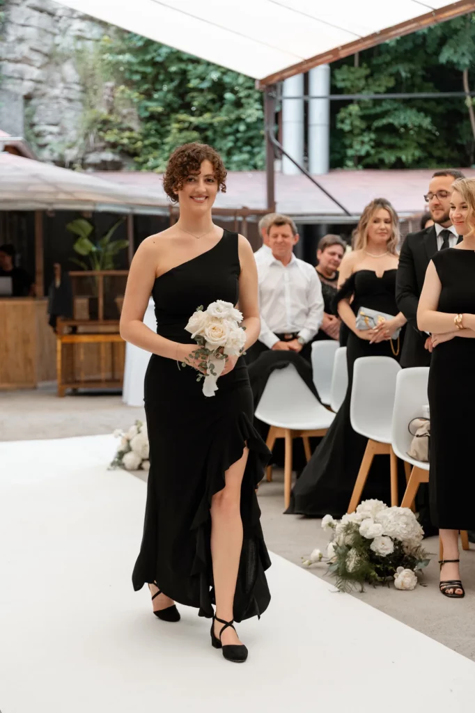 Frau im schwarzen Kleid mit Blumenstrauß