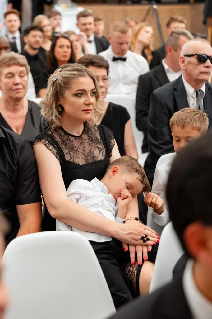 Frau in schwarzer Spitze mit schlafendem Kind