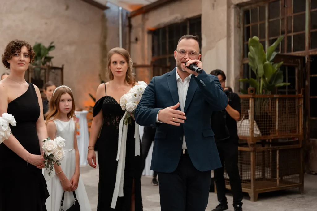 Mann hält Rede mit Mikrofon bei Hochzeit