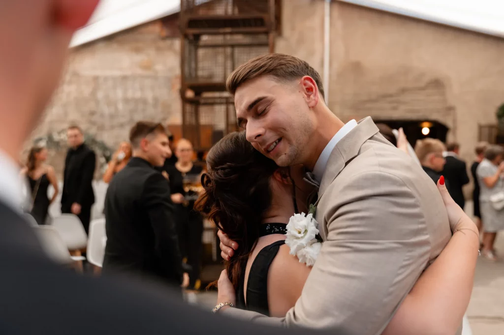 Mann umarmt Frau mit Blumen am Arm
