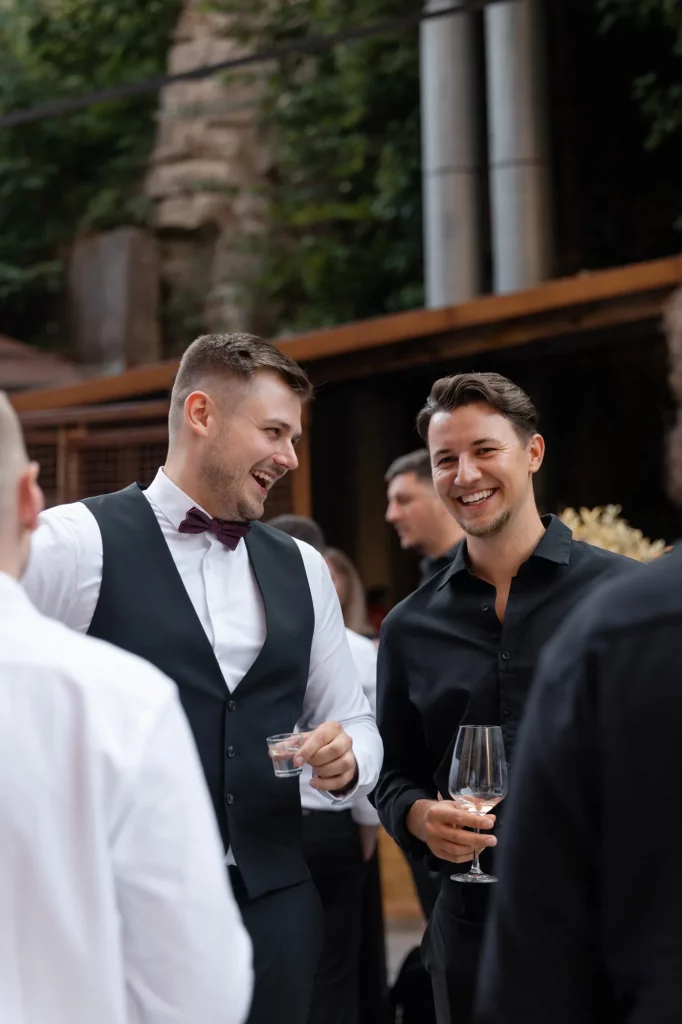 Zwei Männer lachen und halten Gläser