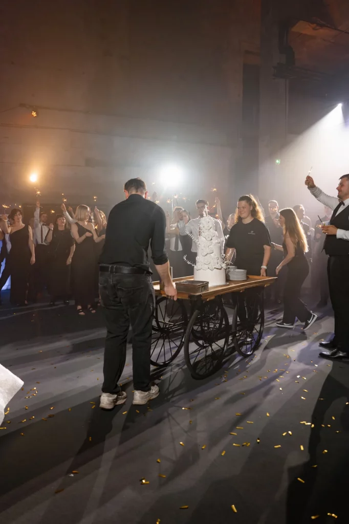 Personen schieben Hochzeitstorte auf Wagen