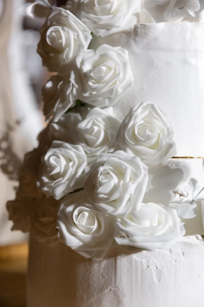weiße Rosen auf mehrstufiger Hochzeitstorte
