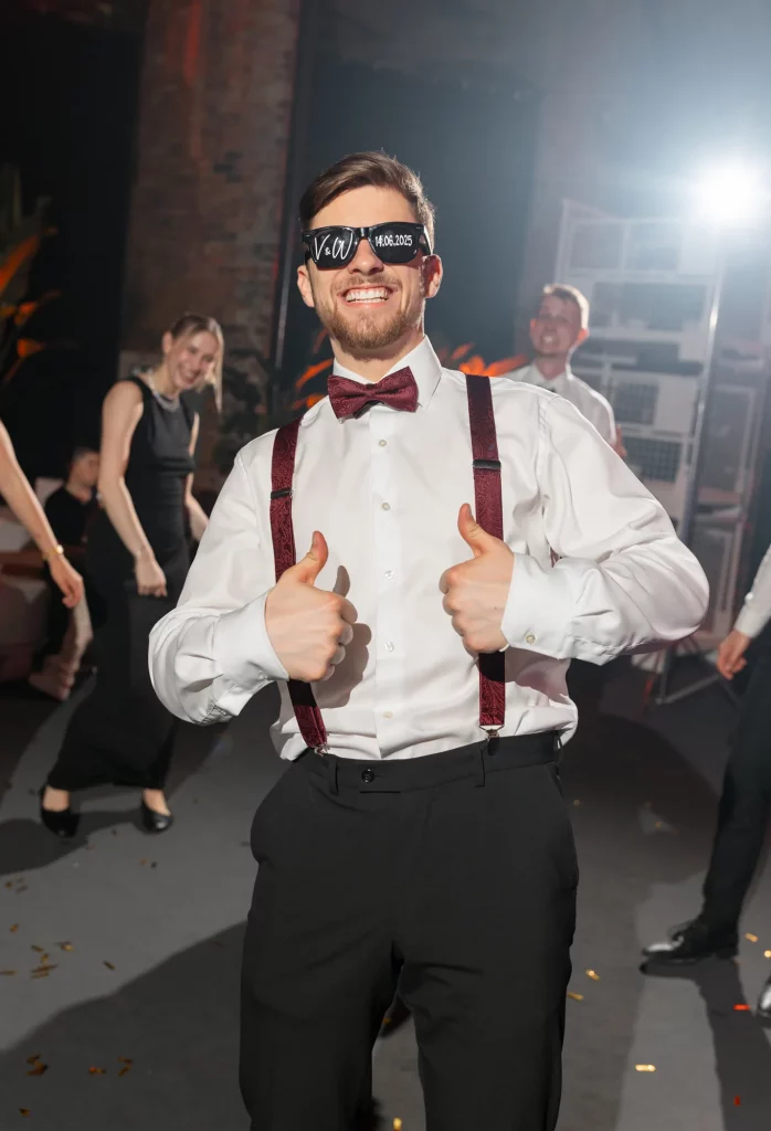 Mann mit Sonnenbrille und Fliege zeigt Daumen hoch