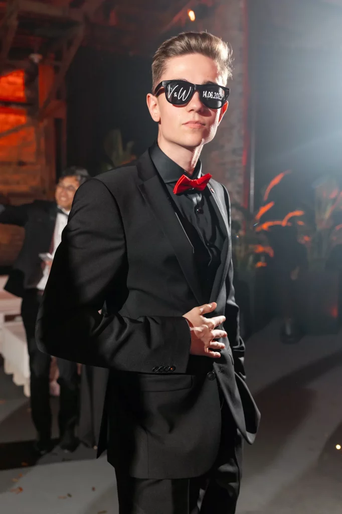 Junger Mann mit roter Fliege und Sonnenbrille