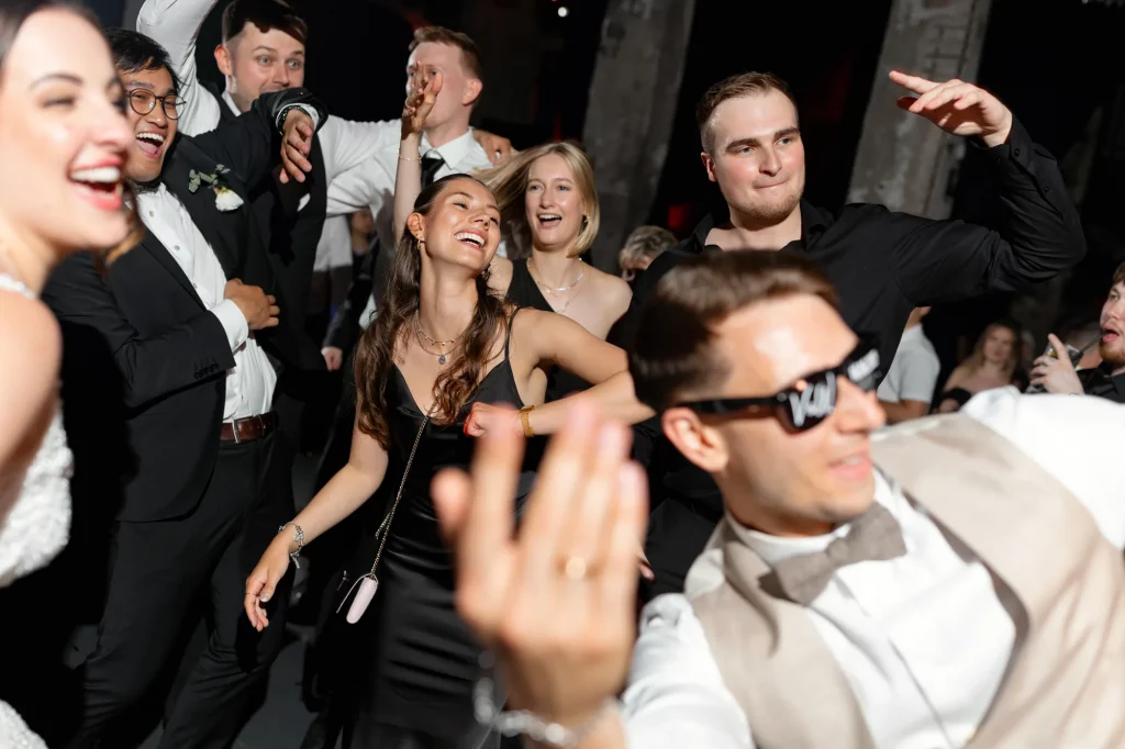 Fröhliche Gäste tanzen ausgelassen auf Hochzeit