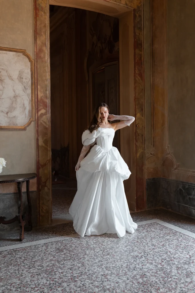 Braut im weißen Kleid an der Tür.