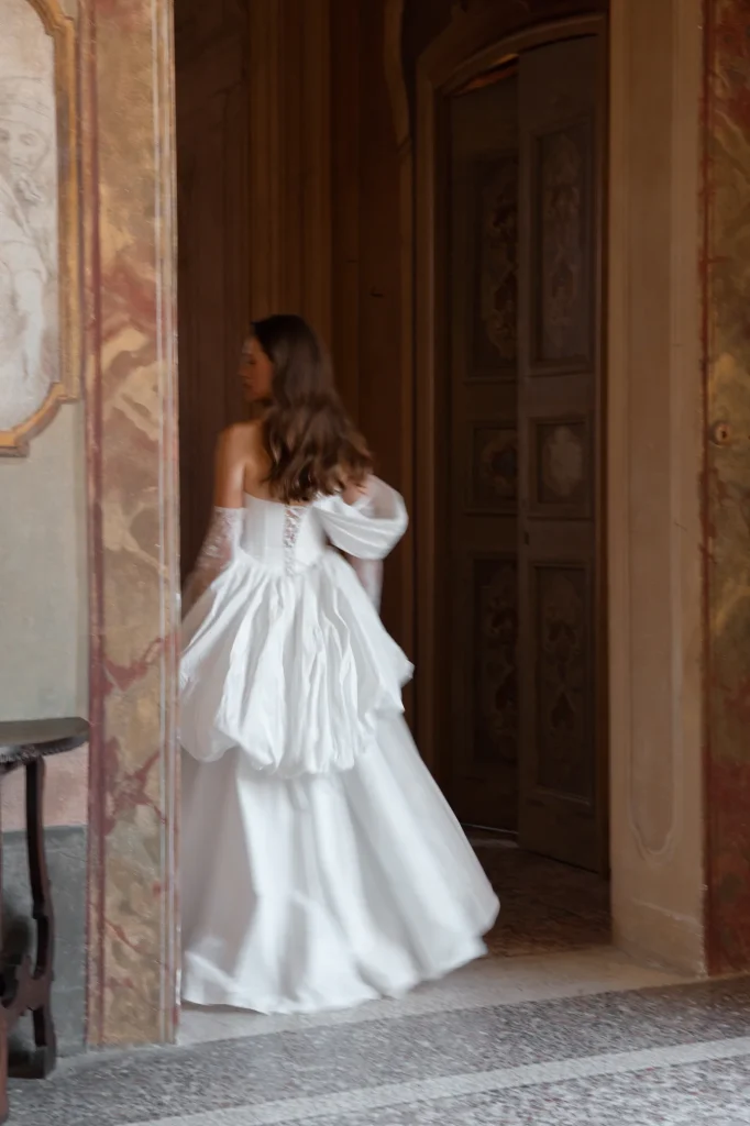 Braut im weißen Kleid an der Tür.