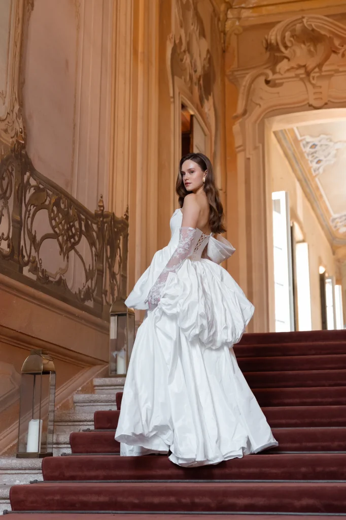 Braut im weißen Kleid auf der Treppe.