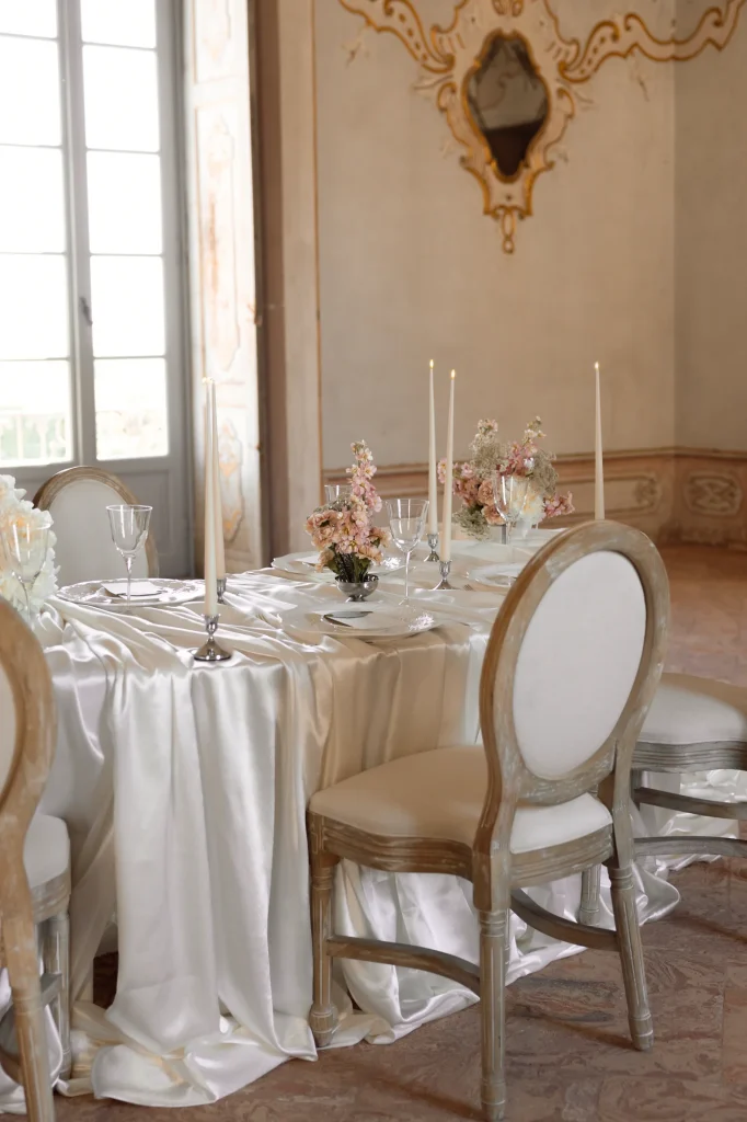 Gedeckter Tisch mit Blumen und Kerzen.
