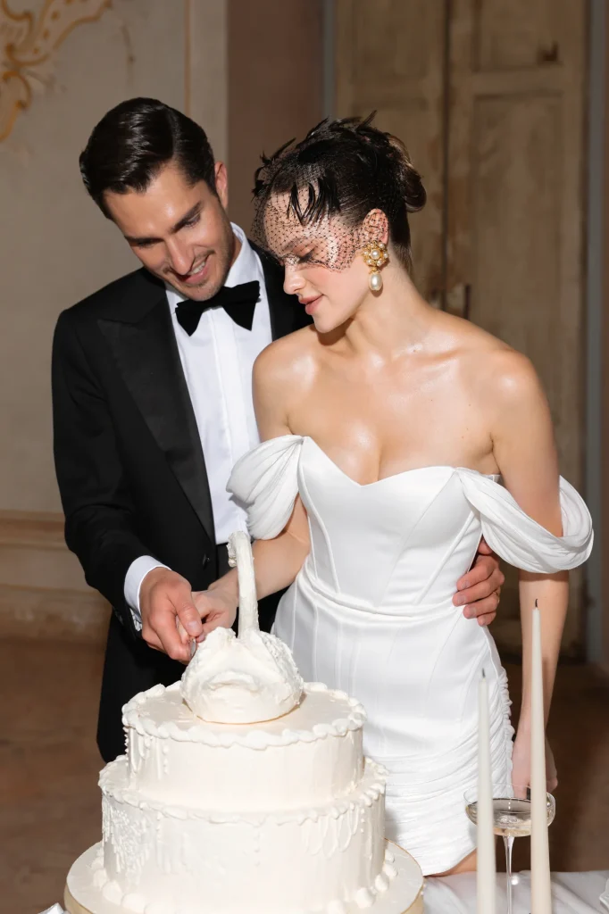 Hochzeitstorte mit Brautpaar und Kerzen.