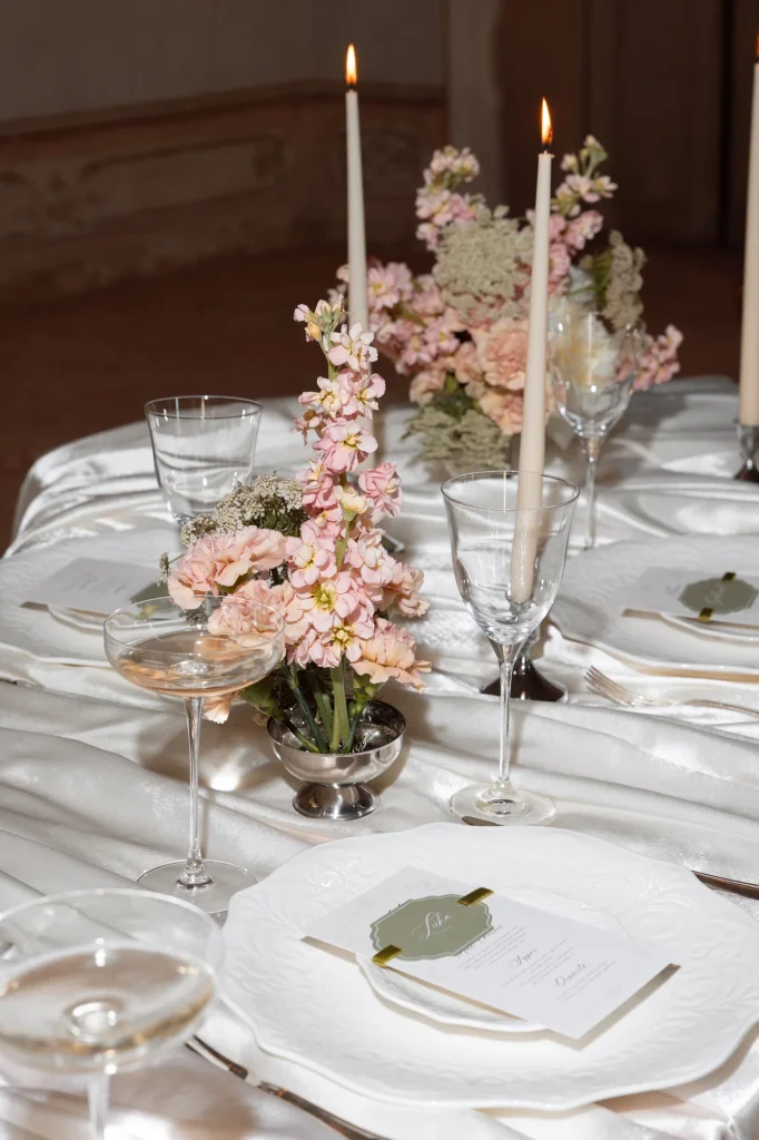 Festtafel mit Blumen, Kerzen und Gläsern.
